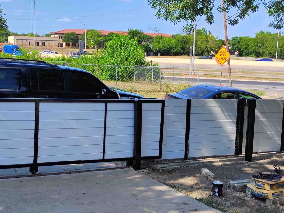 Black cars behind a modern gate