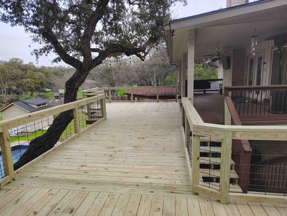 Spacious wooden deck with tree