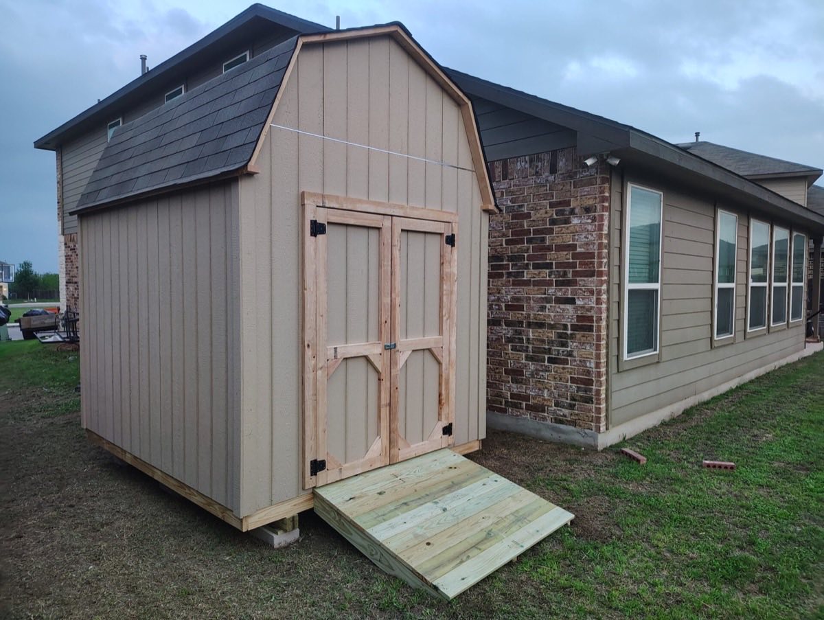Wooden shed with ramp beside house