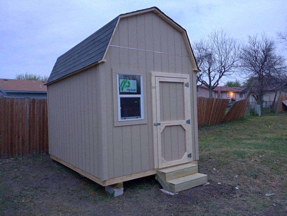 Small wooden shed in grassy area